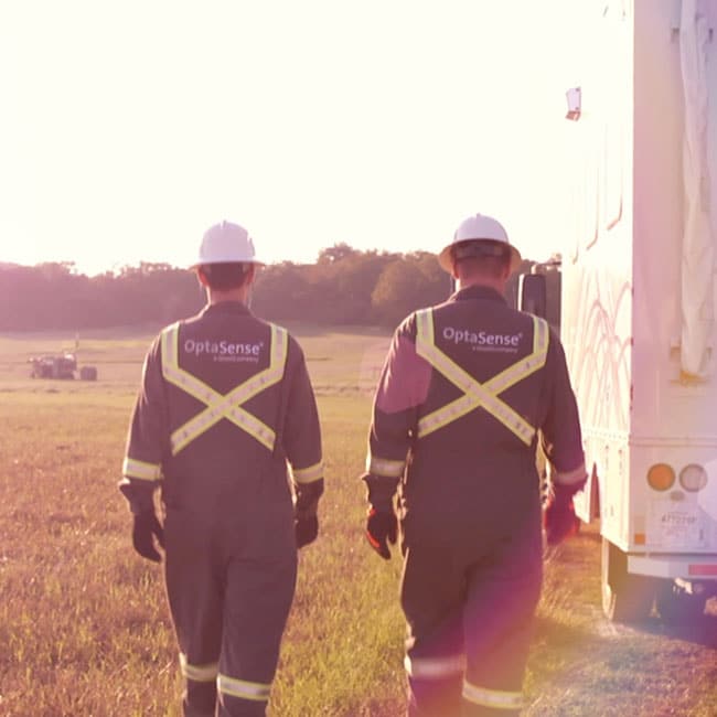 two optasense field technicians walking in field