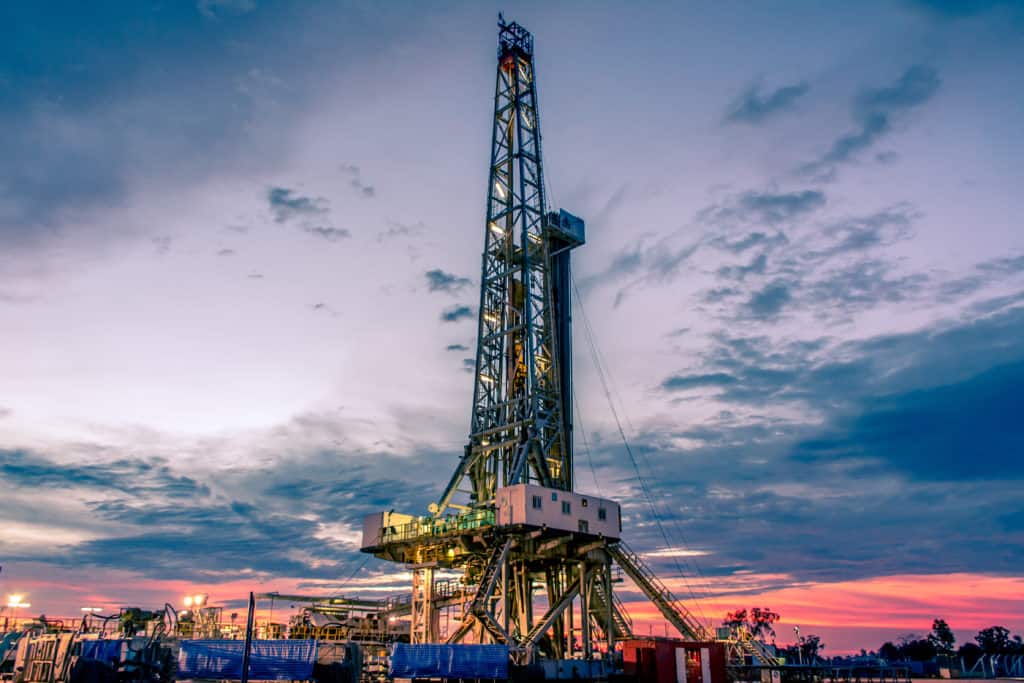 Land oil drilling rig with sunset in background