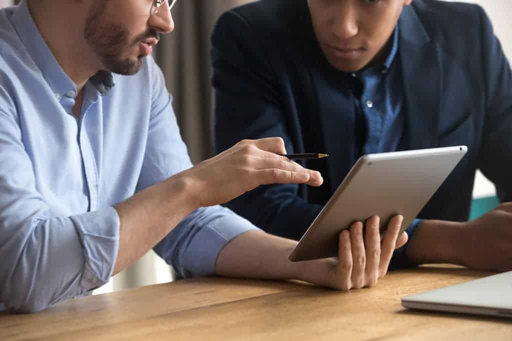 two men looking at tablet