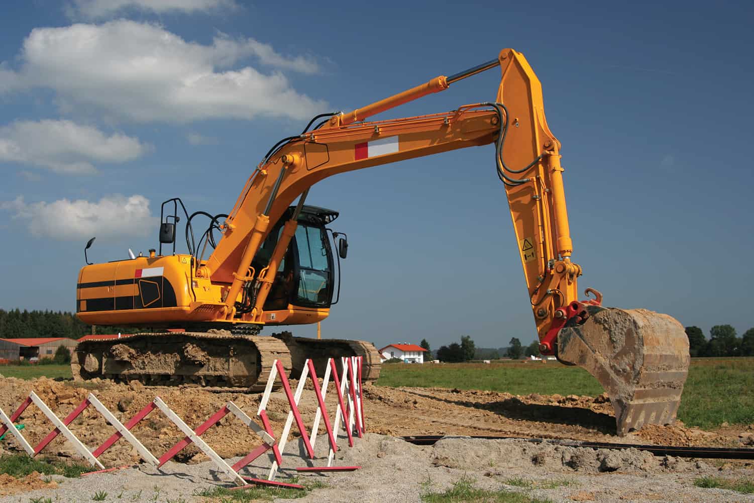 Mechanical Digger in field with safety fence around it
